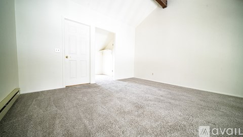 A room with a carpeted floor and a doorway leading to another room.