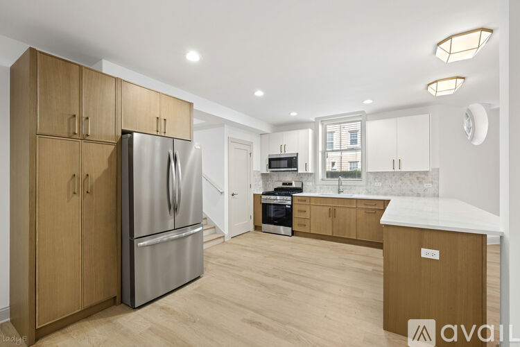 A kitchen with wooden cabinets and a stainless steel refrigerator.