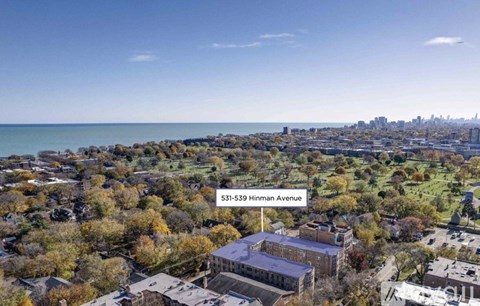 An aerial view of a city with buildings and trees, and a text overlay that reads "531-539 Hinman Avenue".