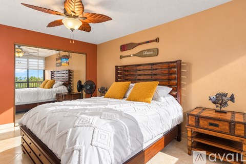 A bedroom with a large bed and a ceiling fan.