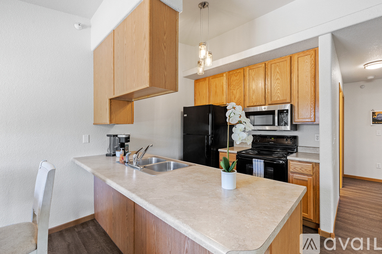 A kitchen with wooden cabinets and a black refrigerator.