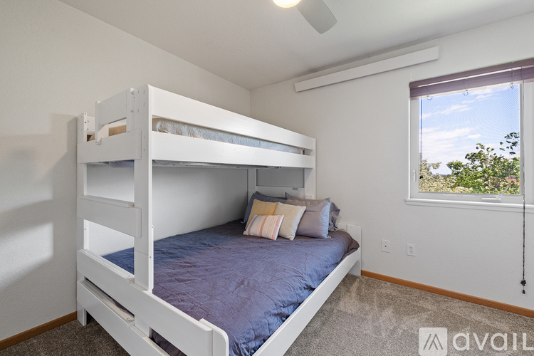 A bedroom with a bunk bed and a window.