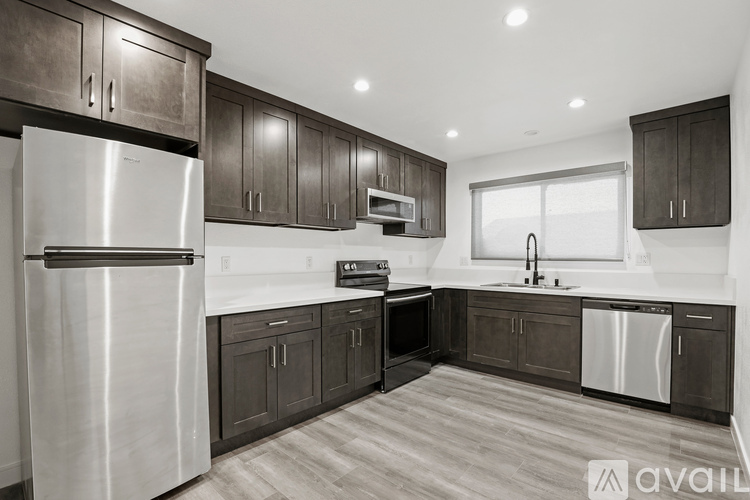 A kitchen with dark wood cabinets and stainless steel appliances.