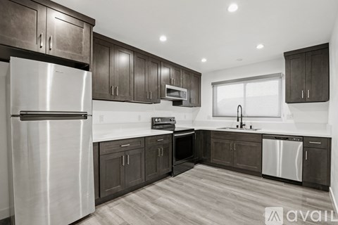 A kitchen with dark wood cabinets and stainless steel appliances.