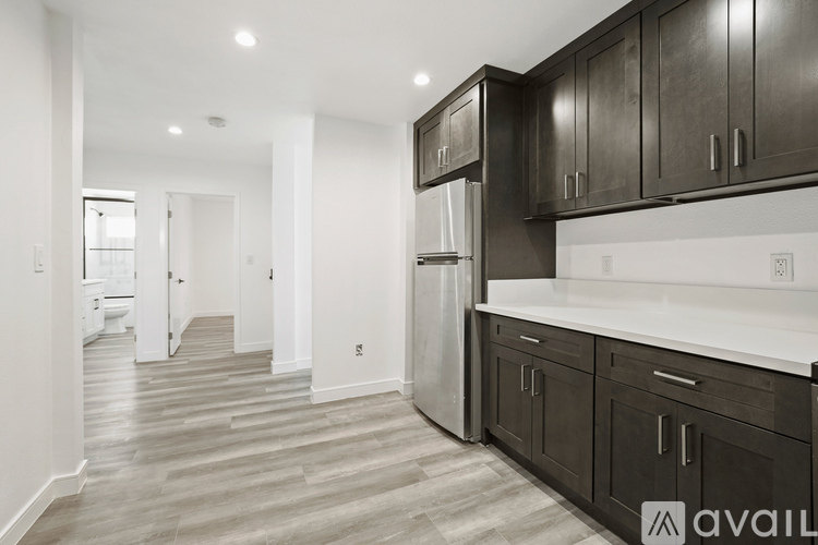 A kitchen with dark wood cabinets and a white countertop.