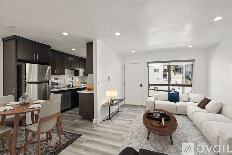 A modern kitchen with a dining table and a living room area.
