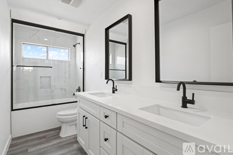 A bathroom with a toilet, sink, and mirror.