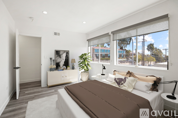 A bedroom with a large bed and a view of the outside through the window.