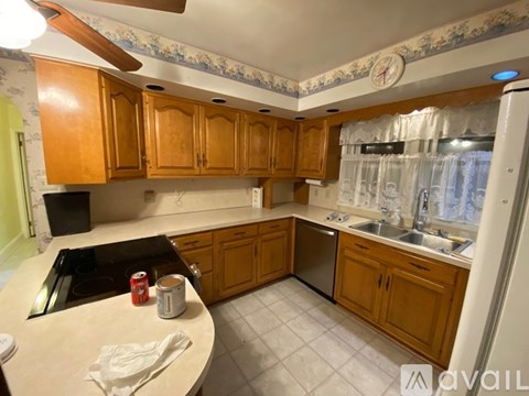 A kitchen with wooden cabinets and a black dishwasher.