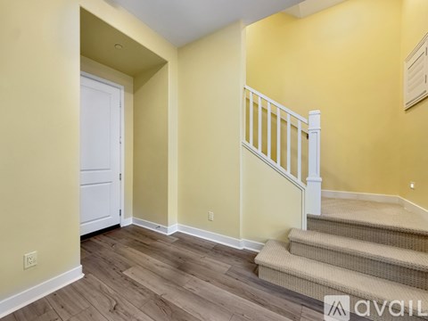 A hallway with a staircase and a white door.
