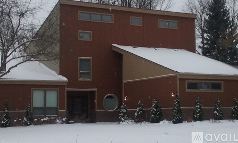 A red house with a snowy front yard.