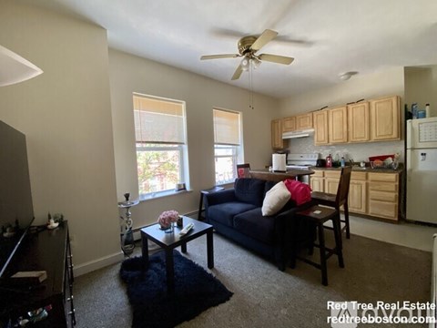 A living room with a black couch and a coffee table.