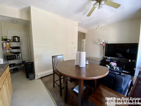 A dining room with a wooden table and chairs.