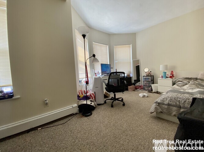 A room with a bed, a desk, and a chair.