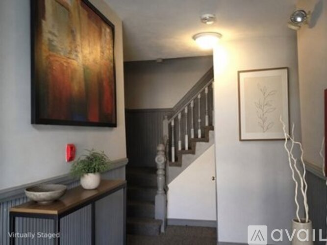 A staircase with a wooden banister and a painting on the wall.