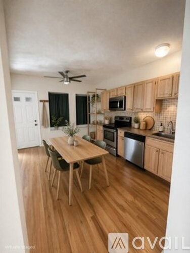 A kitchen with wooden cabinets and a table with chairs.