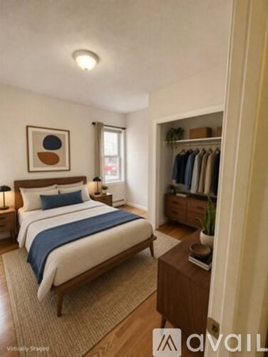 A bedroom with a large bed and a wooden nightstand.