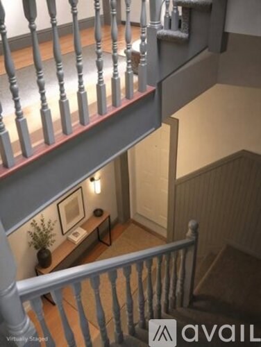 A staircase with a wooden banister and a light on the side.