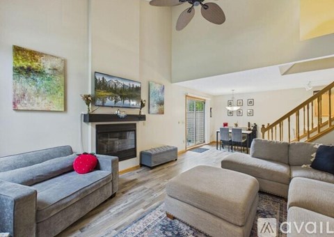 A living room with a grey couch and a fireplace.