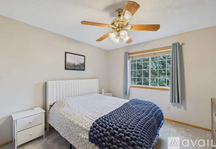 A bedroom with a bed, dresser, and window.