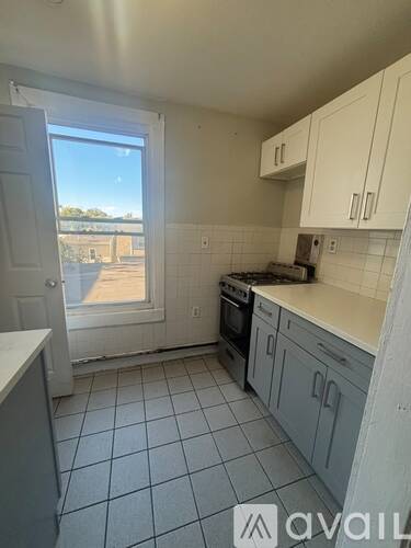 A kitchen with white cabinets and a tiled floor.