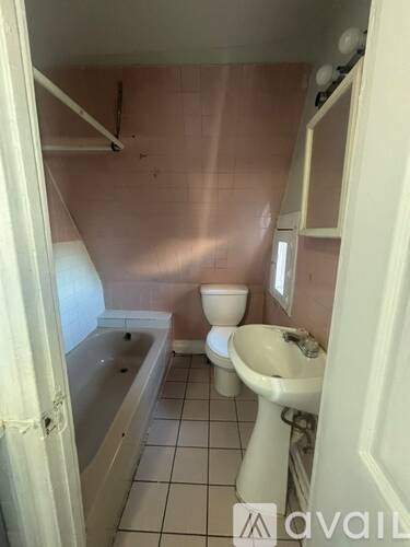 A bathroom with a toilet, sink and bathtub.