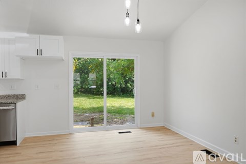 A spacious living room with a fireplace and sliding glass doors leading to a garden.