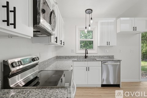 A modern kitchen with white cabinets and stainless steel appliances.