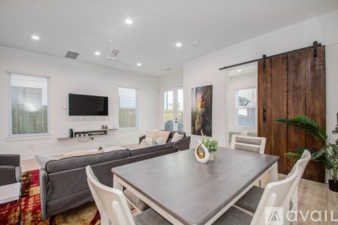 A modern dining room with a wooden table and chairs.