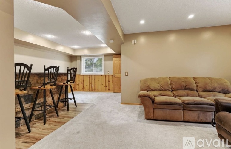 A living room with a brown couch and a wooden floor.