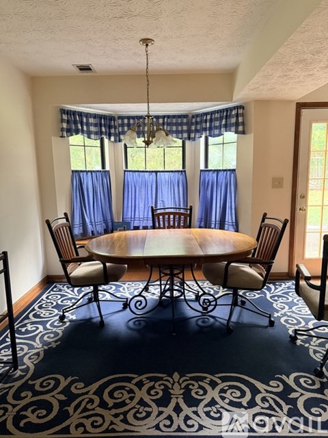 A dining room with a round table and chairs.