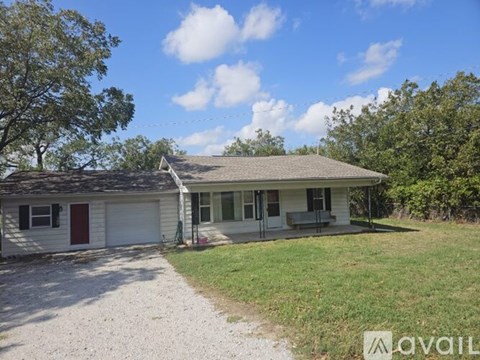 A house with a red door and a garage is for sale.