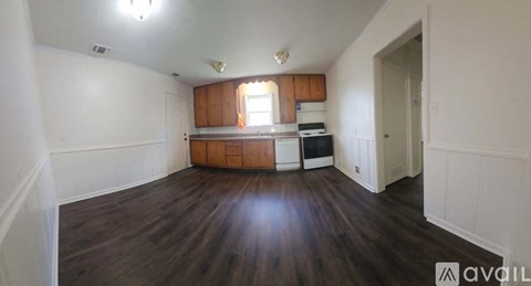 A kitchen area with wooden floors and white walls.