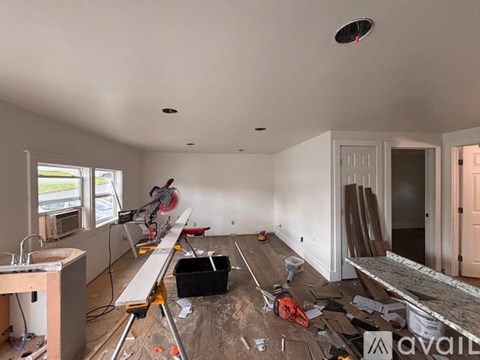 A room under construction with tools and materials scattered on the floor.