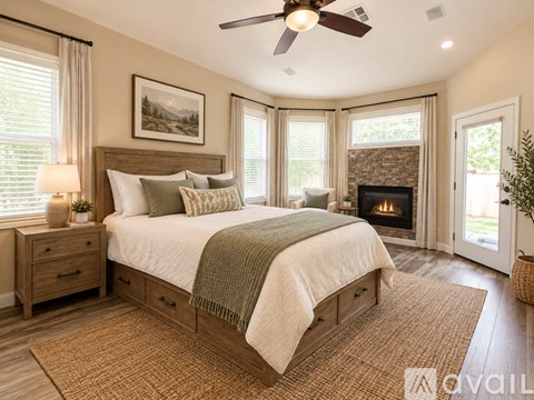 A bedroom with a large bed and a fireplace.