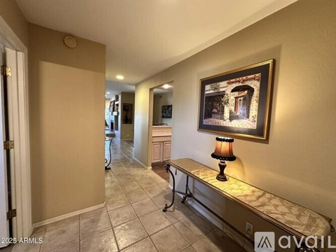 A hallway with a bench and a painting on the wall.