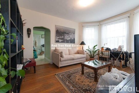 A living room with a couch, coffee table, and a large window.