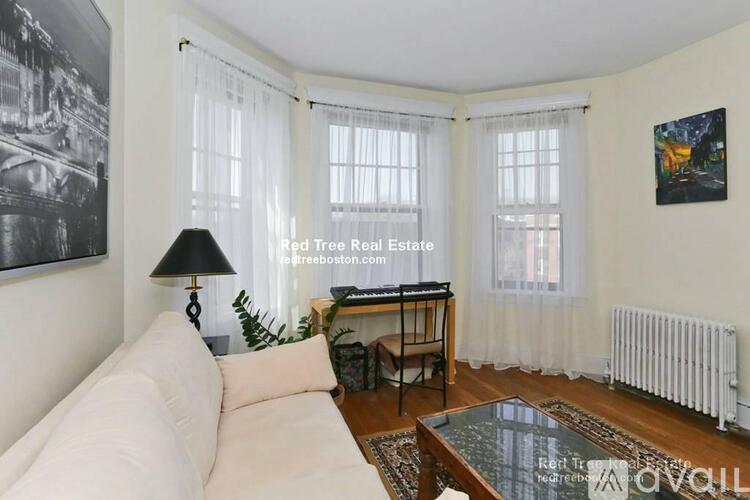 A living room with a couch, coffee table, and a lamp.