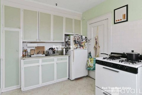 A kitchen with white cabinets and a white stove.