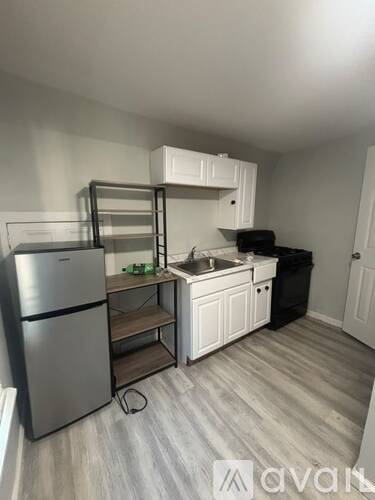 A kitchen with a fridge, sink, and cabinets.