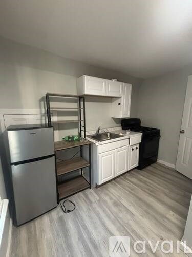 A kitchen with a fridge, sink, and cabinets.