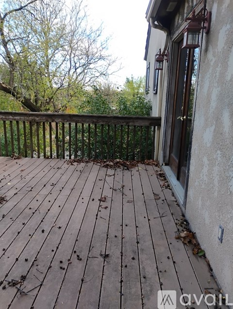 A wooden deck with a railing and a door.