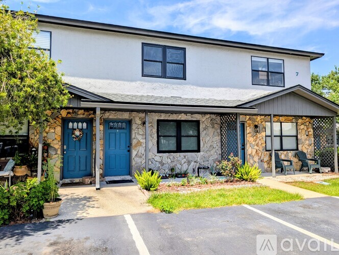 A house with a blue door and windows is for sale.