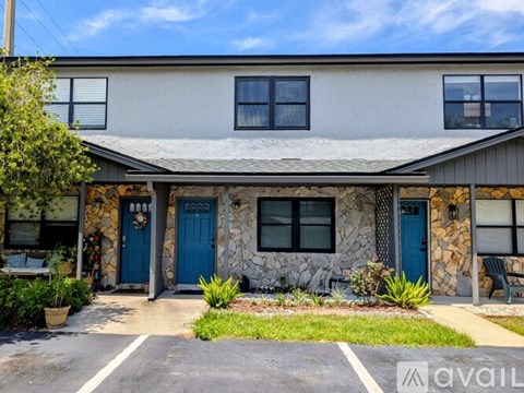 A house with a blue door and a stone wall.