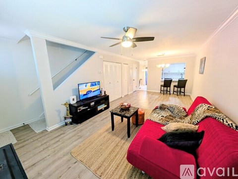 A living room with a red couch and a television.