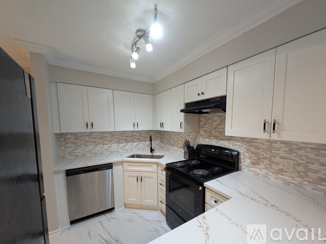 A kitchen with a black stove top oven and a black refrigerator.