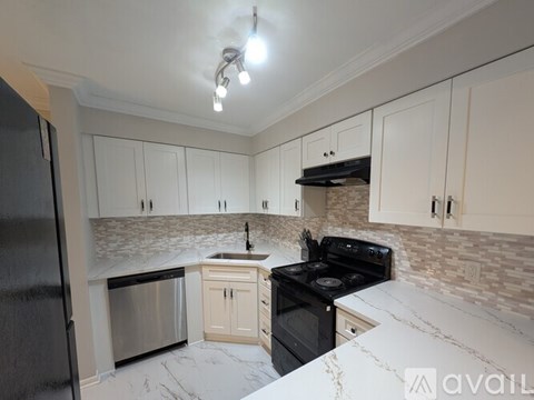 A kitchen with a black stove top oven and a black refrigerator.