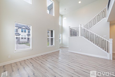 A spacious room with a staircase and windows.