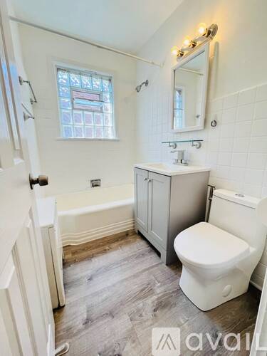 A bathroom with a tub, toilet, and sink.