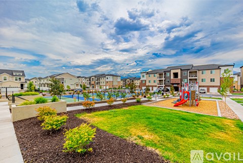 A playground with a slide and a red swing set is surrounded by a grassy area and a sidewalk.